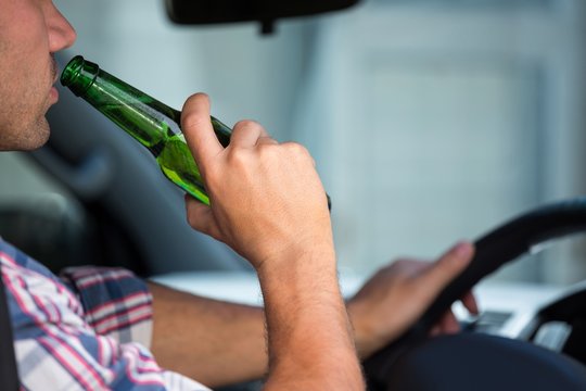 Man drinking beer while driving