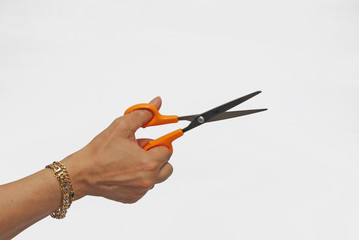Hand holding orange scissors