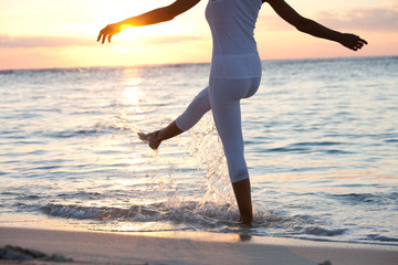plan serré de jambes de femme éclaboussant dans l'eau le soir