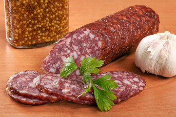 Salami for Breakfast with pepper on a wooden table