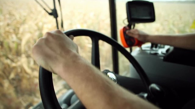 A man driving a combine harvester. View from the cab of the combine.