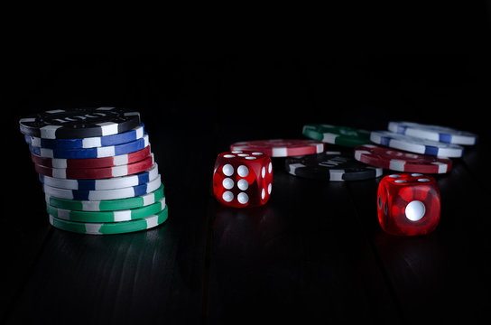 Poker chip  and dice on black background