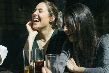 Women laughing and having fun in a bar