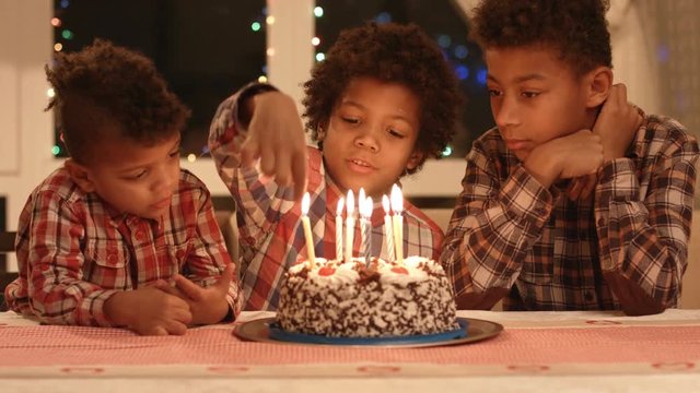 Boy count candles on the cake.