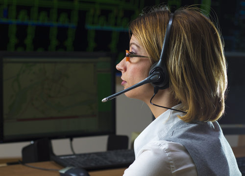 Female Operator  With Headphone In Power Distribution Control Ce