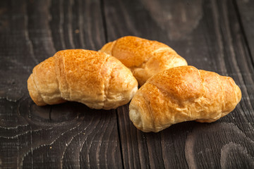 small croissant on wooden background
