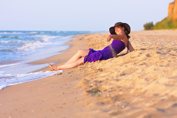 Cute white girl laying on sand at the beach