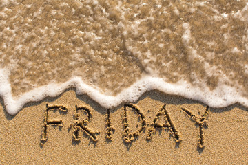 Week series - FRIDAY - written on a sandy beach with the soft wave at sunny day.