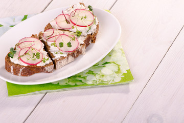 Sandwiches of rye bread with cream cheese and radish