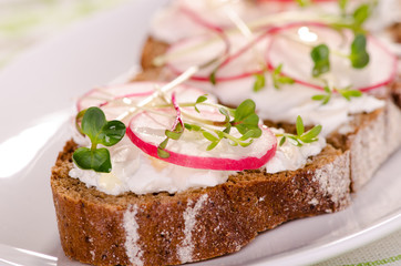 Sandwiches of rye bread with cream cheese and radish