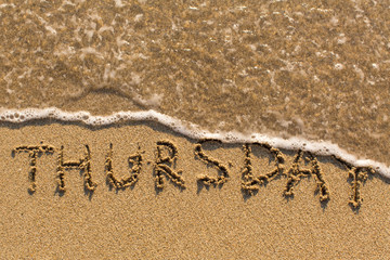 Week series - THURSDAY - written on a sandy beach with the soft wave at sunny day.