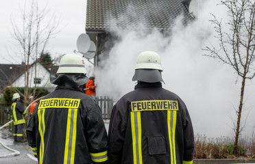 Feuerwehrmänner vor brennendem Gebäude