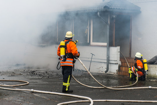 Feuerwehrmänner löschen brennendes Haus