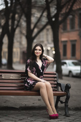 Fototapeta premium Beautiful brunette young woman posing on the street in old city