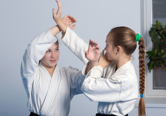 Two girls in black hakama practice Aikido on martial arts training. Selective focus