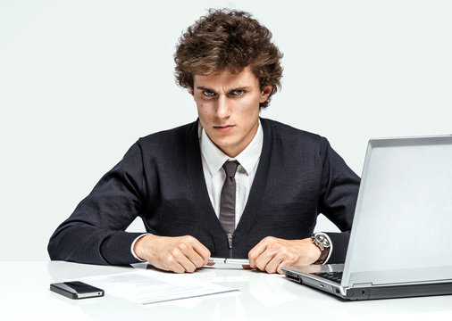 Modern businessman at the workplace working with computer, depression and crisis concept
