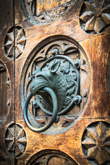 Antique door knocker shaped monster's head.