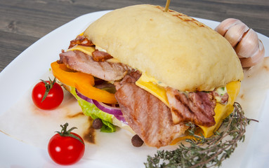 burger with meat, tomato, onion, cheese, lettuce on wooden table