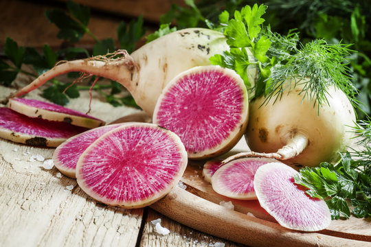 Slices Of Pink Watermelon Radish On A Wooden Table With Parsley