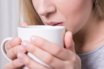 close up of woman drinking coffee or tea