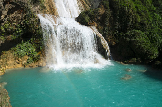View to amazing waterfall with turquoise pool surrounded by gree