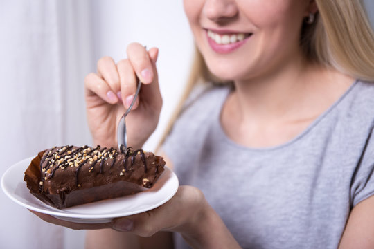 Young Smiling Woman Eating Chocolate Cake At Home