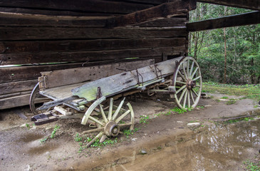 Fototapeta na wymiar Abandoned Pioneer Wagon. Abandoned pioneer wagon left to deteriorate beside a barn. Great Smoky Mountain National Park. Gatlinburg, Tennessee.