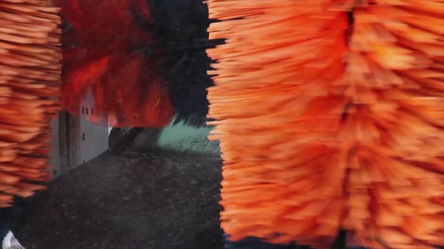 T&uacute;nel de Lavado de Coches Autom&aacute;tico - Procesos en la secuencia completa del  Lavado de un coche de color negro  - Rodillos girando con agua y jabon en el proceso de lavar la carroceria del  coche