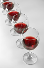 Glasses of red wine on white table closeup