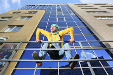 .a young man in overalls on background glassed building