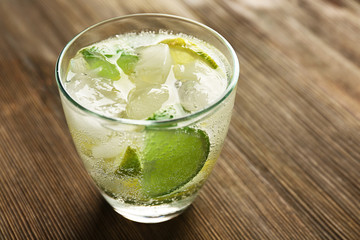 Mojito drink with lime on wooden table