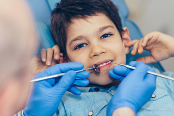 Smiling boy having regular dental examination