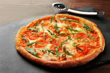 Margherita pizza with knife on slate plate
