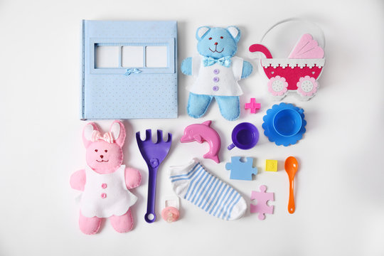 Baby's toys with photo album and socks on white background