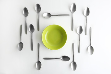 Plate and silver spoons, top view
