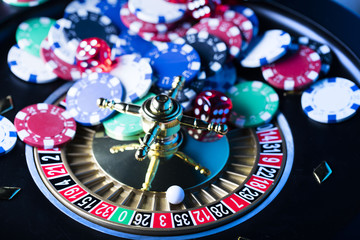 casino theme, high contrast image of casino roulette, playing chips and dice