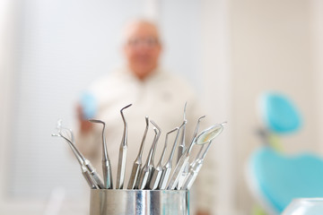 Metallic dentist tools close up and background blur with patient