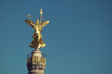 Fototapeta na wymiar golden bronze sculpture (Goldelse) on the Victory Column (Siegessaeule), Berlin, Germany, Vintage Style 