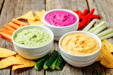 multicolored hummus with vegetables and chips
