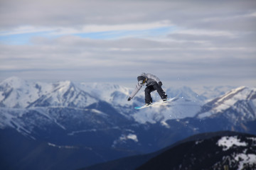 Flying snowboarder on mountains. Extreme sport.