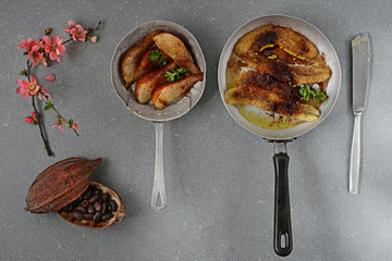 banane e pere flambé in padelle vecchie sfondo grigio