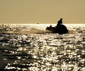 Foto op Canvas Silhouette of man on jetski at sea © maxoidos