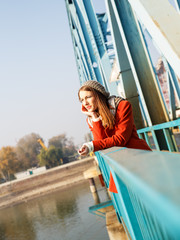 Portrait of a beautiful young brunette woman on the bridge