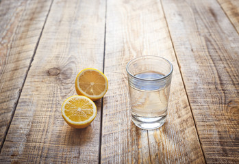 glass of water with lemon on wooden table