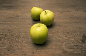 Three apples on wood table