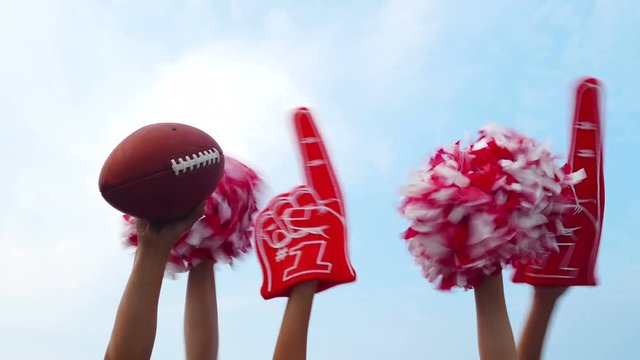 Tailgate: Football And Poms Held Up Against Blue Sky