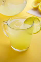 Water and lemon in yellow background