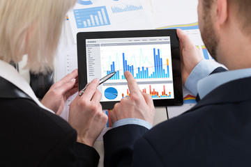 Two Businesspeople Analyzing Graph On Digital Tablet