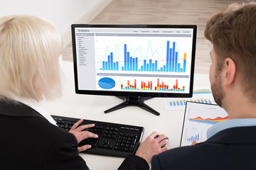 Businesspeople Analyzing Graph On Computer