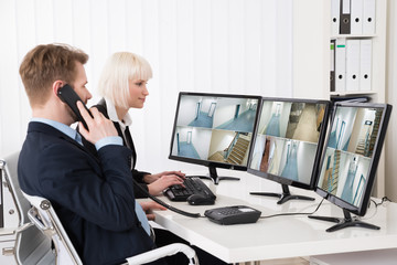 Businesspeople Looking At Multiple Camera Footage